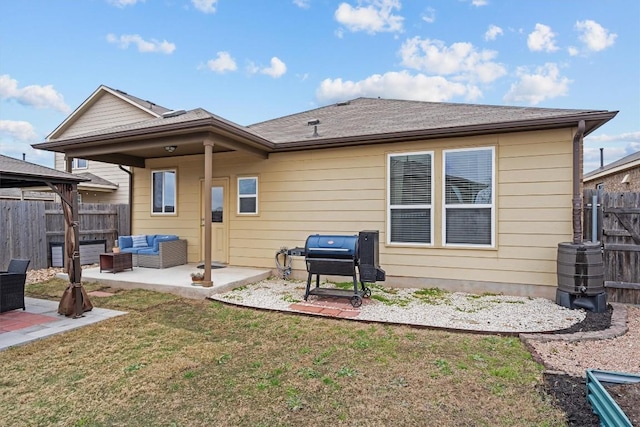 back of property with a lawn, a patio, roof with shingles, fence, and an outdoor living space