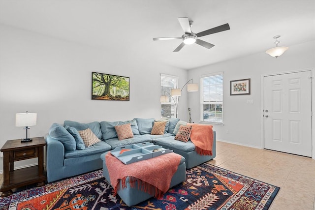 living room featuring ceiling fan, baseboards, and light tile patterned flooring