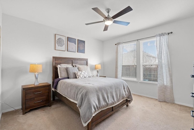 bedroom with light colored carpet, ceiling fan, and baseboards