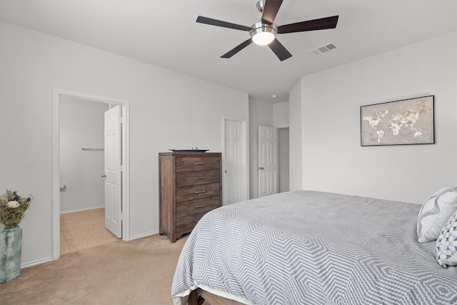 bedroom with light carpet, ceiling fan, visible vents, and baseboards