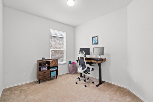 office space featuring light carpet and baseboards