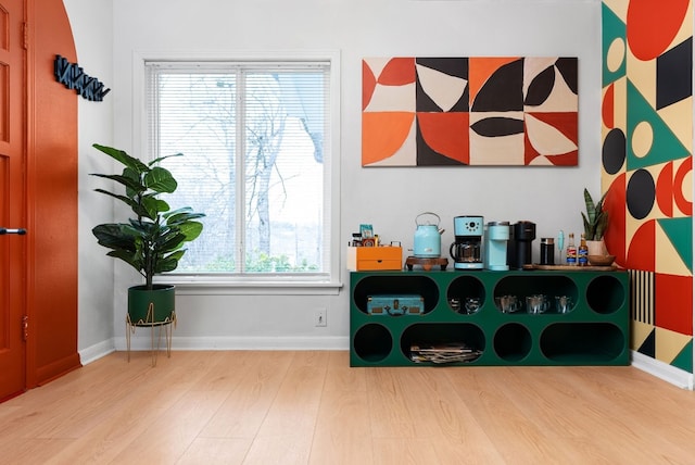 recreation room with a wealth of natural light, baseboards, and wood finished floors