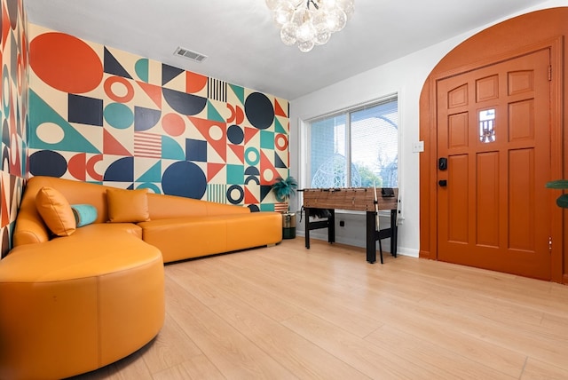 902 E Live Oak St, Austin, TX 78704 - entryway with an accent wall, wallpapered walls, baseboards, wood finished floors, and a chandelier