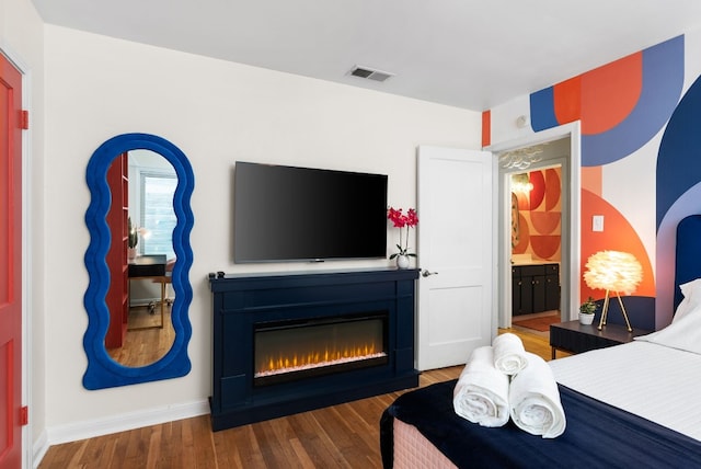 902 E Live Oak St, Austin, TX 78704 - bedroom featuring a glass covered fireplace, baseboards, and wood finished floors