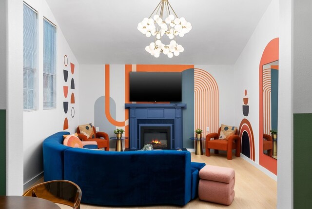 living area with a warm lit fireplace, light wood-style flooring, and baseboards