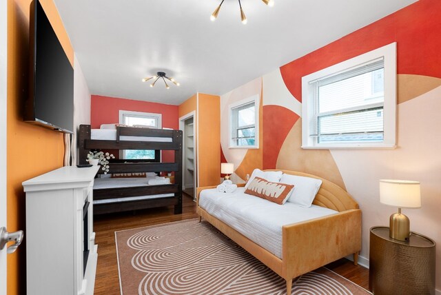 902 E Live Oak St, Austin, TX 78704 - bedroom with wood finished floors, a chandelier, and baseboards