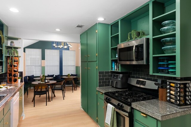 kitchen featuring open shelves, green cabinets, stainless steel appliances, and light wood finished floors