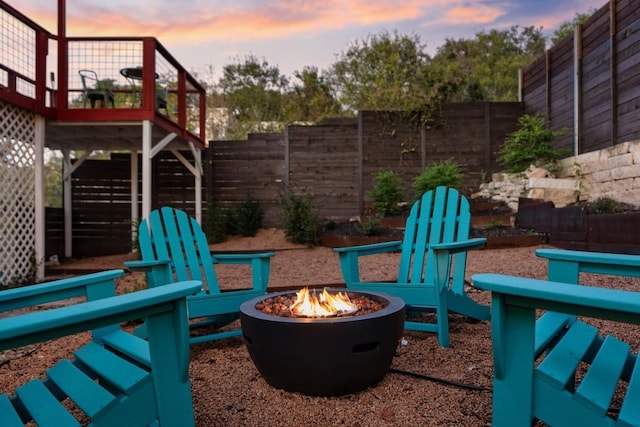 view of jungle gym featuring a fenced backyard and a fire pit