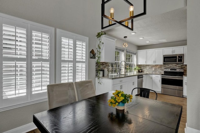 dining area with a textured ceiling and wood finished floors