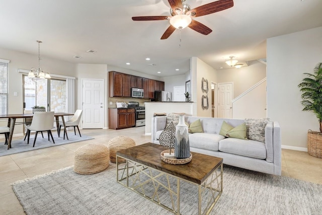 living area featuring baseboards, light tile patterned floors, ceiling fan with notable chandelier, and recessed lighting