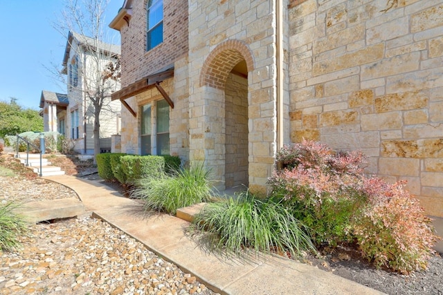 doorway to property with stone siding and brick siding