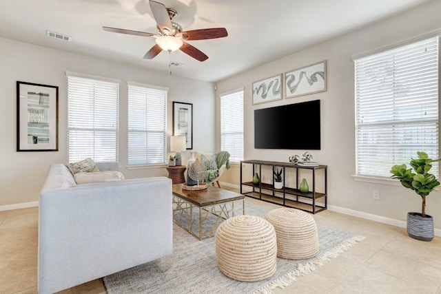 living area featuring visible vents, ceiling fan, baseboards, and light tile patterned floors