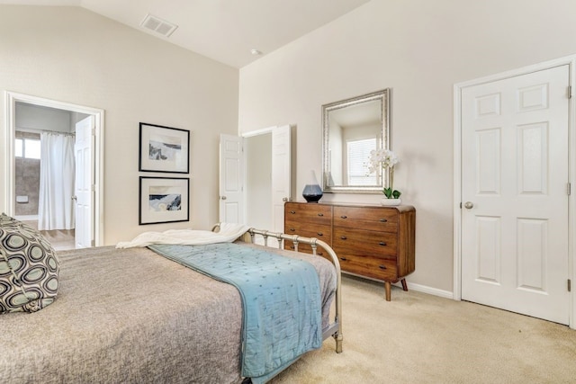 bedroom with lofted ceiling, multiple windows, visible vents, and light colored carpet