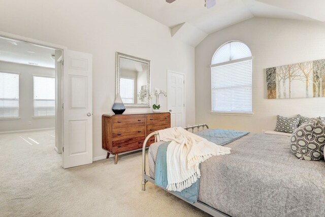 bedroom with lofted ceiling, ceiling fan, baseboards, and light colored carpet