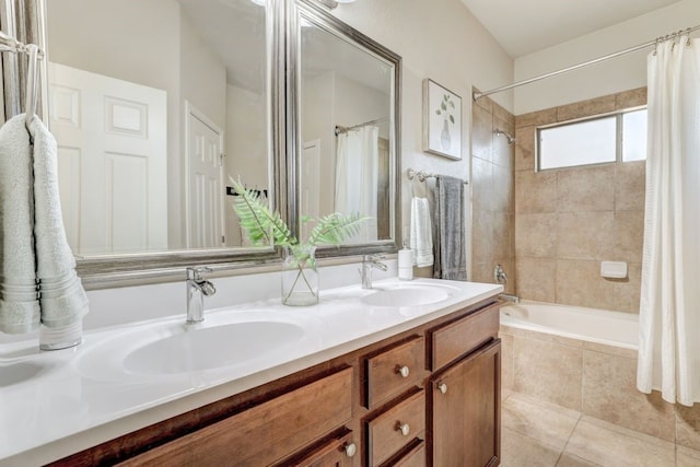 bathroom featuring tiled shower / bath, double vanity, a sink, and tile patterned floors