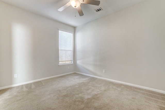 carpeted empty room featuring visible vents, ceiling fan, and baseboards