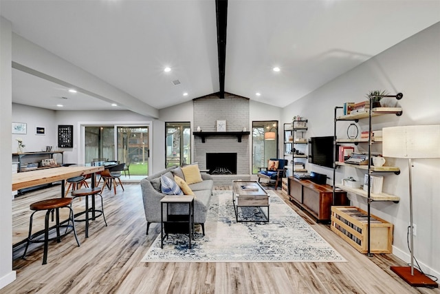 living area featuring light wood-style flooring, recessed lighting, a brick fireplace, and lofted ceiling with beams