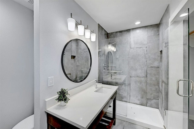 full bath featuring toilet, tiled shower, and vanity