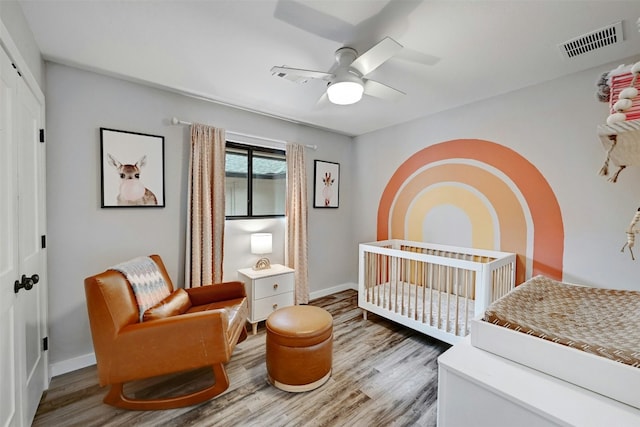 3010 Burleson Rd Unit A, Austin, TX 78741 - bedroom featuring wood finished floors, a nursery area, and a ceiling fan