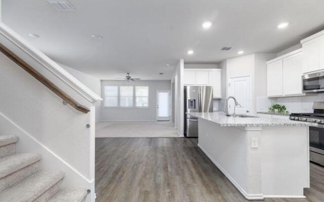 8329 Morningside Pl, Schertz, TX 78154 - kitchen featuring stainless steel appliances, open floor plan, white cabinetry, light stone counters, and recessed lighting