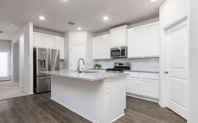 8329 Morningside Pl, Schertz, TX 78154 - kitchen with stainless steel appliances, a sink, an island with sink, white cabinetry, and recessed lighting