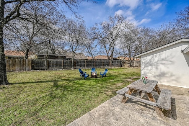 view of yard with a fire pit, outdoor dining space, a patio area, and a fenced backyard