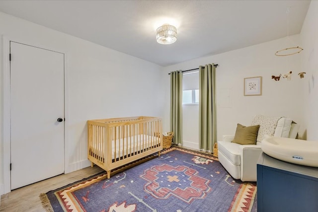 bedroom with a crib and wood finished floors