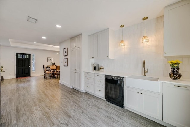 kitchen with pendant lighting, black dishwasher, light countertops, and white cabinets