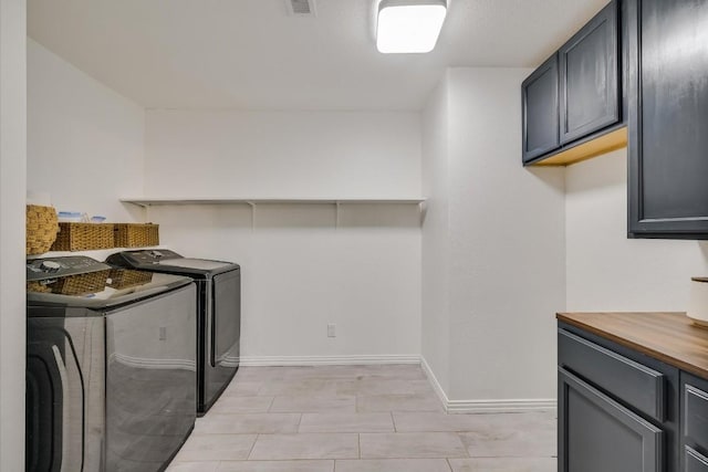 clothes washing area with cabinet space, baseboards, and washer and clothes dryer