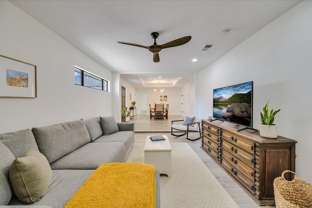 10104 Oak Hollow Cir, Austin, TX 78758 - living room with light wood-style floors, a ceiling fan, a tray ceiling, and recessed lighting