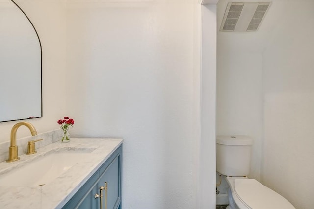 bathroom featuring toilet, visible vents, and vanity