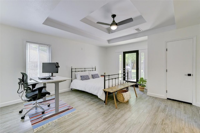 10104 Oak Hollow Cir, Austin, TX 78758 - bedroom with a raised ceiling, light wood finished floors, a desk, and baseboards