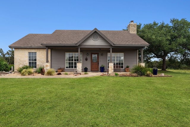 view of front facade with a chimney, a front lawn, and roof with shingles