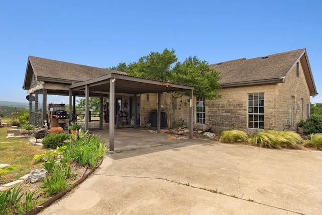 201 Hillview Cir, Dripping Springs, TX 78620 - rear view of property featuring stone siding, driveway, and a shingled roof