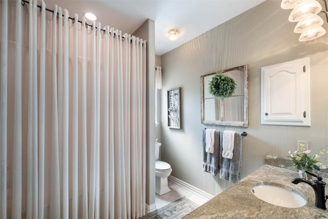 bathroom with tile patterned floors, vanity, toilet, and baseboards