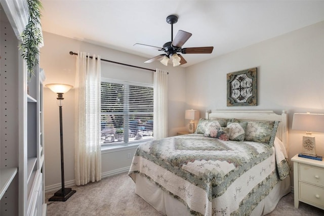 bedroom featuring baseboards, ceiling fan, and light colored carpet