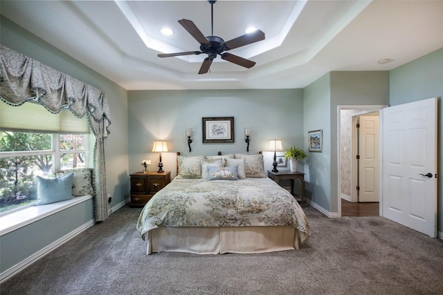 bedroom featuring baseboards, ceiling fan, a tray ceiling, dark colored carpet, and recessed lighting