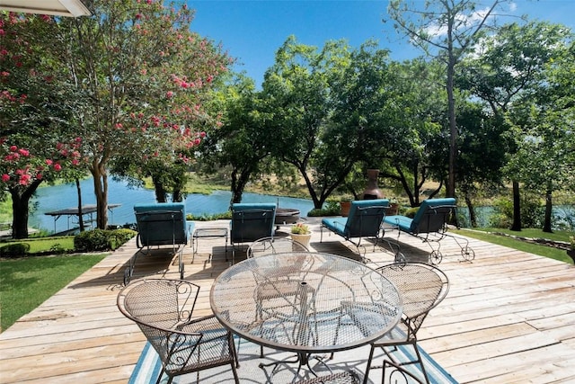 deck featuring outdoor dining area and a water view