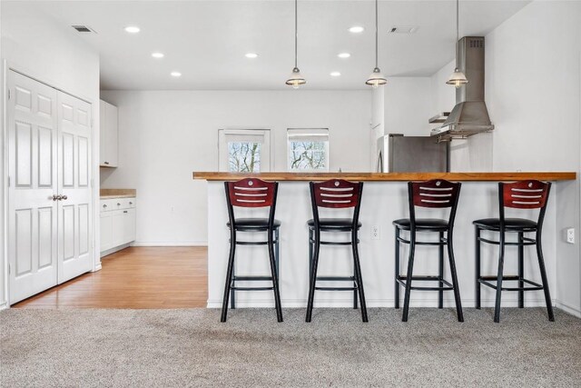 826 Savannah Cv, Elgin, TX 78621 - kitchen with island range hood, freestanding refrigerator, light colored carpet, white cabinets, and recessed lighting