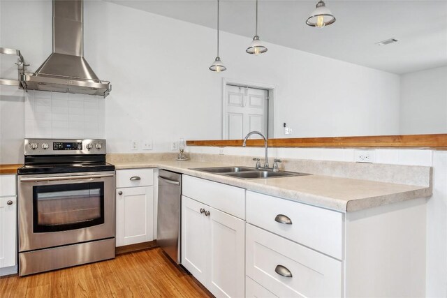 826 Savannah Cv, Elgin, TX 78621 - kitchen featuring appliances with stainless steel finishes, wall chimney exhaust hood, a sink, and light countertops