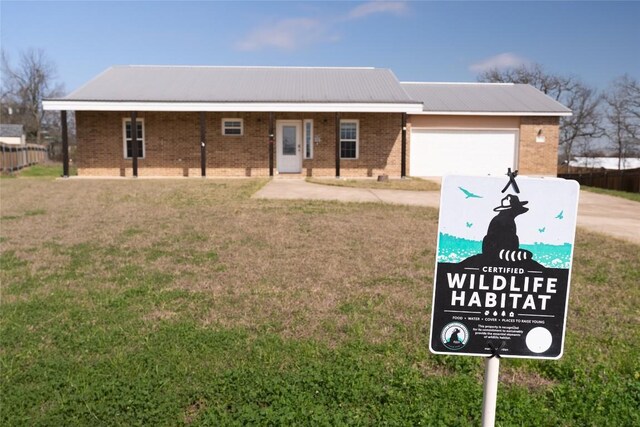 826 Savannah Cv, Elgin, TX 78621 - ranch-style home with driveway, brick siding, a front yard, a garage, and metal roof