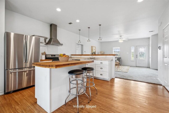 826 Savannah Cv, Elgin, TX 78621 - kitchen featuring freestanding refrigerator, butcher block counters, island range hood, a sink, and white cabinetry
