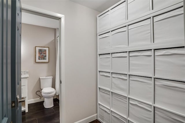 bathroom featuring baseboards and toilet