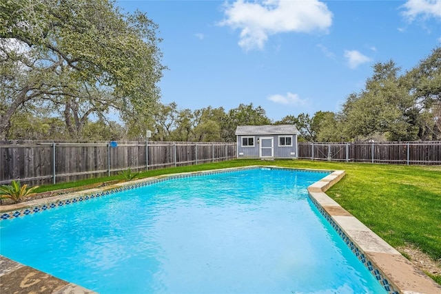 view of pool featuring a fenced backyard, a shed, a lawn, and an outbuilding