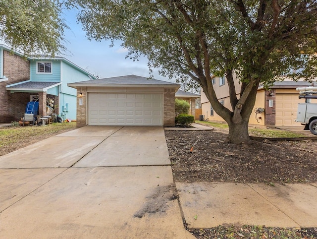 view of front of property with driveway, an attached garage, and brick siding