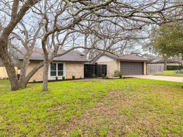 view of front of home featuring concrete driveway, brick siding, a front lawn, and fence