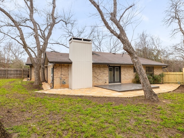 8205 Alabama Dr, Austin, TX 78745 - rear view of property featuring brick siding, a patio, roof with shingles, and a chimney