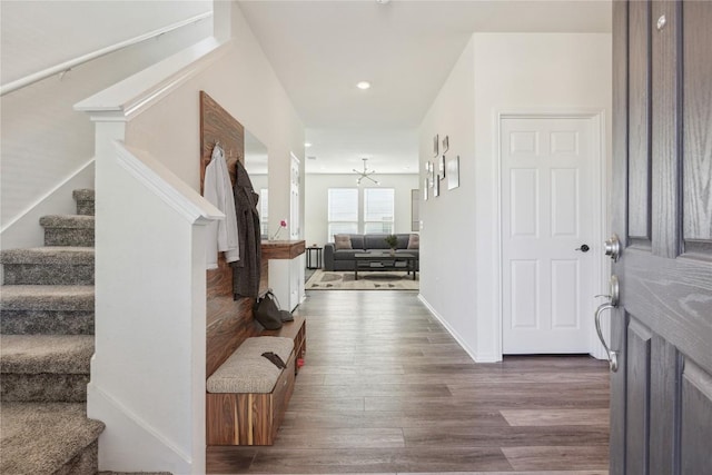 foyer entrance featuring a notable chandelier, recessed lighting, baseboards, stairs, and dark wood-style floors