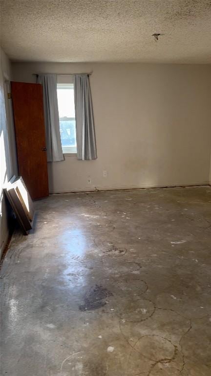 unfurnished room featuring concrete flooring and a textured ceiling