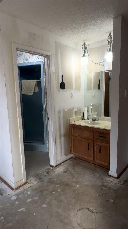 bathroom with a textured ceiling, concrete floors, and vanity